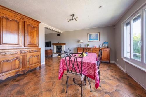 une salle à manger avec une table et un tissu de table rose dans l'établissement Maison confortable avec jardin à Le Tréport, au Tréport