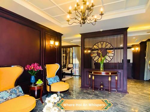 a hotel lobby with chairs and a table and a chandelier at Happy Life Memories Hoi An Hotel & Spa in Hoi An