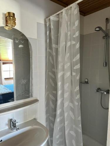 une salle de bain avec un rideau de douche et un lavabo dans l'établissement Haut de villa indépendant dans quartier calme, à Saint Cyprien Plage