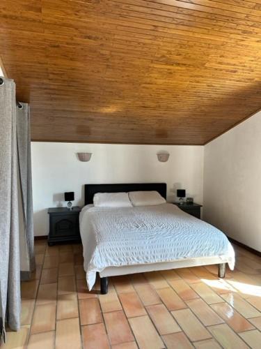 une chambre avec un lit avec un plafond en bois dans l'établissement Haut de villa indépendant dans quartier calme, à Saint Cyprien Plage