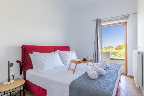 een slaapkamer met een rood en wit bed en een tafel bij Stella by Hospi in Kato Gouves