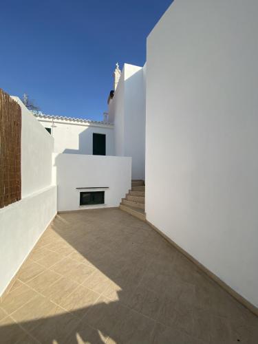 a view from the courtyard of a house with white walls at Refúgio No16 Ocean Air & Rooftop Flair in Albufeira