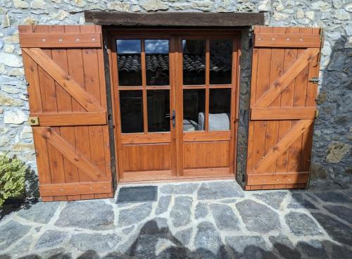 a pair of wooden doors on a stone building at La caseta de Mas Salelles 