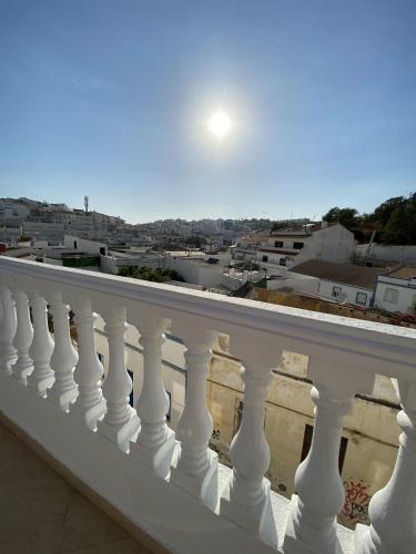 a white balcony with a view of the city at Refúgio No16 Ocean Air & Rooftop Flair in Albufeira
