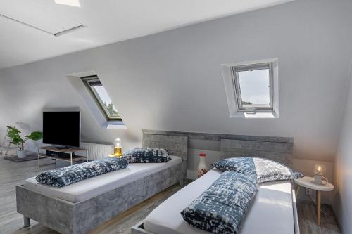 two beds in a room with two windows at Klein Amerika in Storkow
