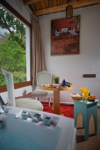 a living room with a table and chairs and a window at Riad Atlas Bangalow in Imlil