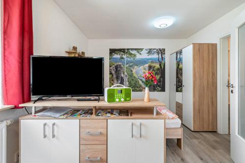 a living room with a tv on top of a cabinet at Ferienwohnung Marks - Hohnstein in Rathewalde