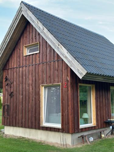 a wooden cabin with a gambrel roof at Sepa Puhkekeskus in Käina