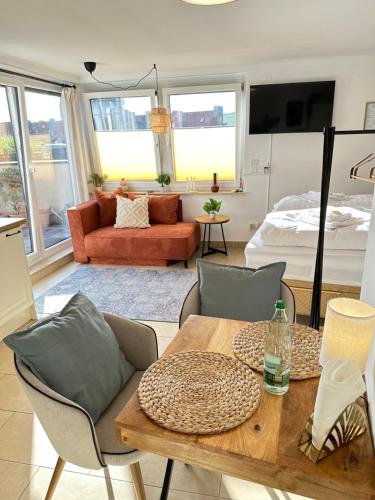 een woonkamer met een tafel en een bed bij Würzburg Studio mit Dachterrasse - Tiefgarage & Nähe Bahnhof in Würzburg