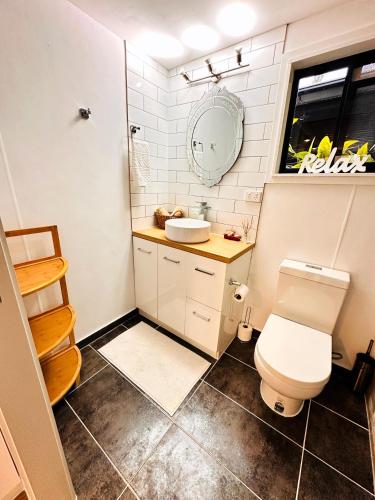 a small bathroom with a toilet and a sink at Tranquil Balinese Retreat in a resort style oasis in Gold Coast