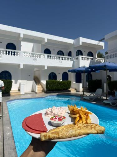 ein Tablett mit Essen auf einem Tisch im Pool in der Unterkunft Sea Horse Hotel Dahab in Dahab