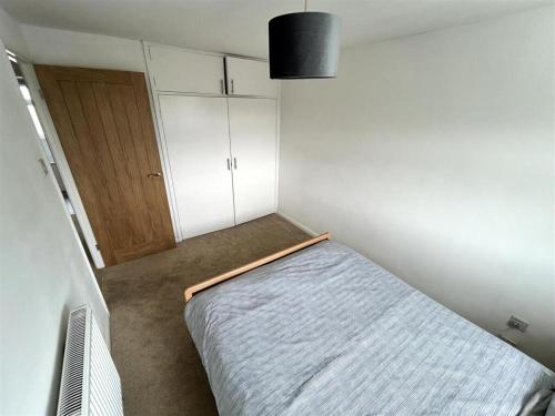 a small bedroom with a bed and a closet at Home in Kington St Michael in Kington St Michael