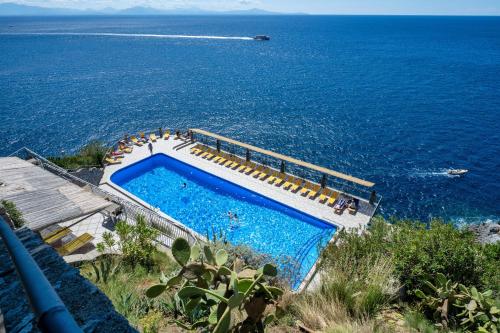a swimming pool next to the ocean with at Hotel Belvedere in Conca dei Marini