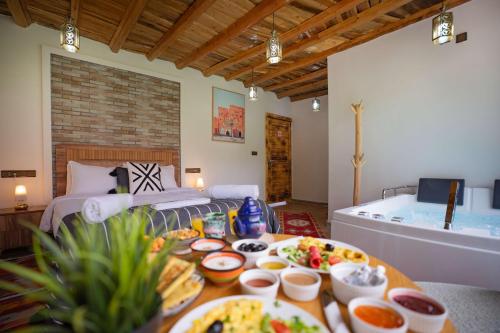 a room with a bed and a table with food on it at Riad Atlas Bangalow in Imlil