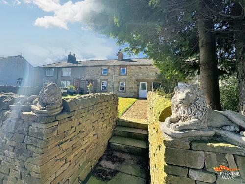 two statues of lions on a stone wall at 14 Pennine Road, Halton-Lea-Gate in Coanwood