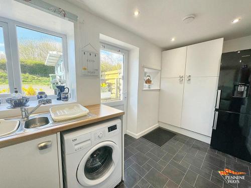 a kitchen with a washing machine and a sink at 14 Pennine Road, Halton-Lea-Gate in Coanwood