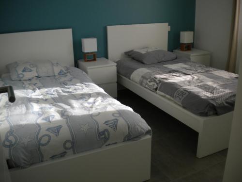 a bedroom with two beds and two night stands at Nokanhui in Soulac-sur-Mer