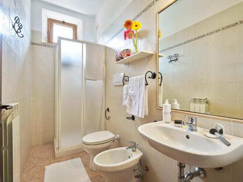 a bathroom with a sink and a toilet and a mirror at Casa Vacanze Santa Caterina in Asciano