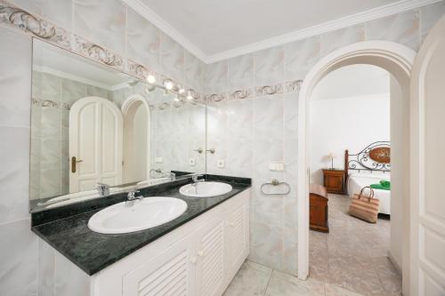 a bathroom with two sinks and a large mirror at Villa Alisa in Tías