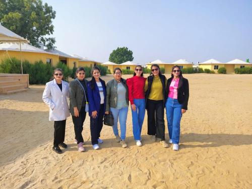 a group of people posing for a picture on the beach at Hotel Robin Jaisalmer Near fort view in Jaisalmer