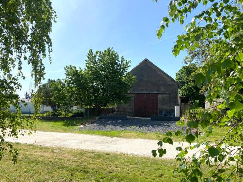 an old barn with a tree and a dirt road at LOFT Köveskál in Köveskál