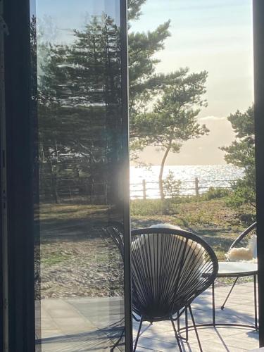 a chair sitting on a porch looking out at the water at Seaside Rendezvous 2 in Kalana