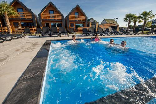 a group of people in a swimming pool at a resort at Ross-Domki in Sarbinowo