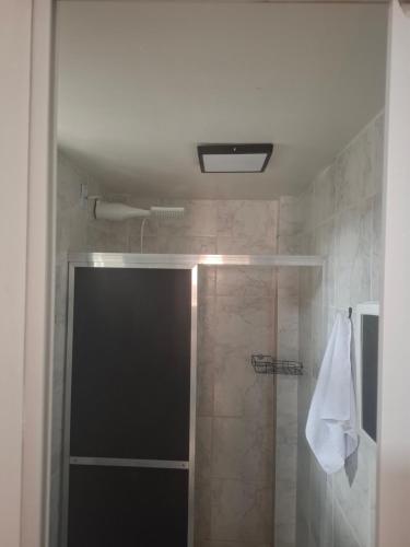 una doccia con una porta in vetro in un bagno di Como uma onda no mar a Rio de Janeiro