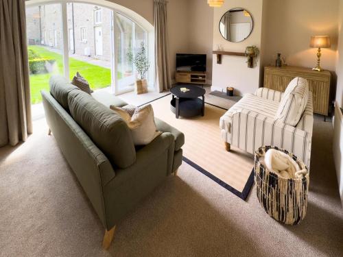 a living room with a couch and a chair at Farmhouse Feels & Peak Views in Pott Shrigley