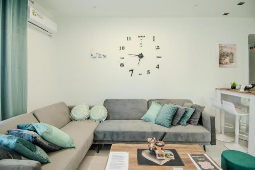 a living room with a couch and a clock on the wall at Zoi Elegant Green Apartments in Filiatra
