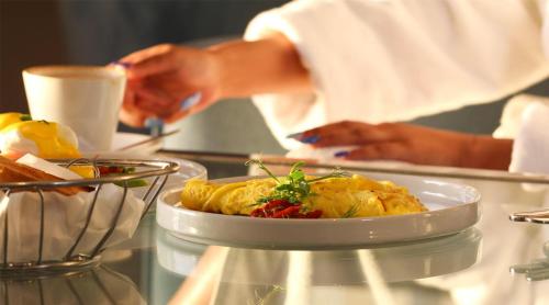 een bord voedsel op een tafel met een bord voedsel bij Radisson Collection Hotel, Waterfront Cape Town in Kaapstad