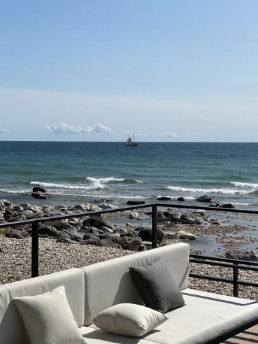 a white couch sitting on a beach near the ocean at Seaside Rendezvous in Kalana