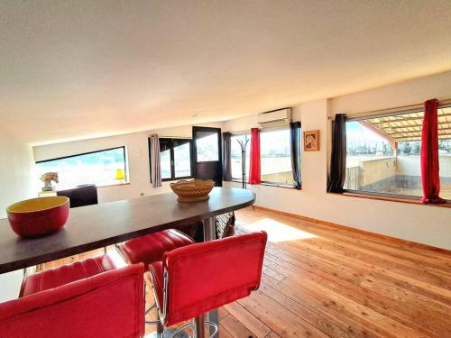 une salle à manger avec une table et des chaises rouges dans l'établissement Le Bureau du Haras, Bouillargues, à Bouillargues