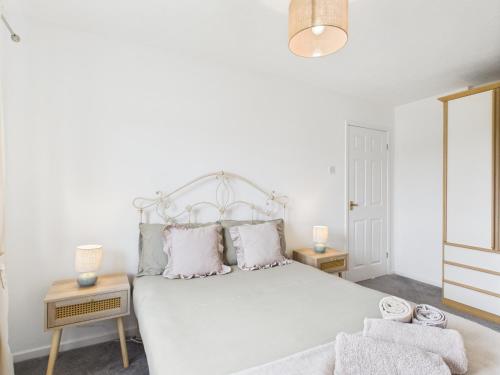 a bedroom with a large white bed with two tables at Modern 3 bed home Wolverhampton New Cross Hospital City Center in Fallings Park