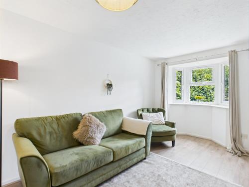 a living room with a green couch and a window at Modern 3 bed home Wolverhampton New Cross Hospital City Center in Fallings Park