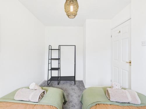 two beds in a white room with a mirror at Modern 3 bed home Wolverhampton New Cross Hospital City Center in Fallings Park