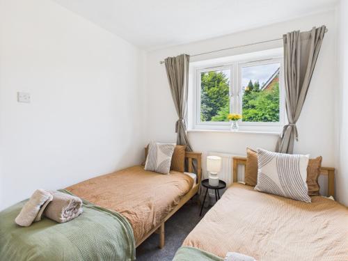 two beds in a room with a window at Modern 3 bed home Wolverhampton New Cross Hospital City Center in Fallings Park