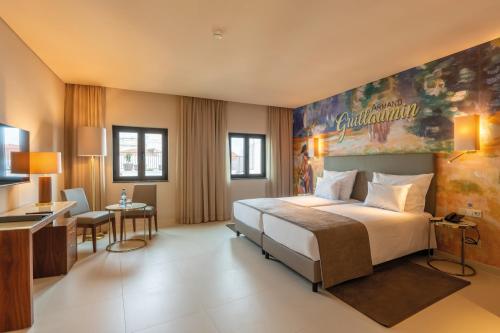 a hotel room with a large bed and a desk at Vila Galé Casas d'Elvas - Historic Hotel in Elvas