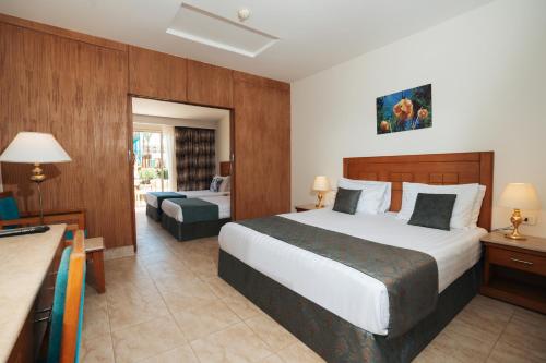 a hotel room with a large bed and a desk at Riviera Aqua Park Resort in Hurghada