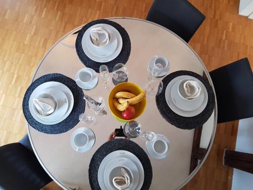 a dining table with plates and glasses and a bowl of food at GRANDE SUITE with kitchen dish washer, dryer washer in Zürich