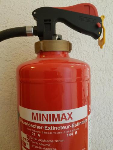 a fire extinguisher on top of a fire extinguisher extinguisher container at GRANDE SUITE with kitchen dish washer, dryer washer in Zürich