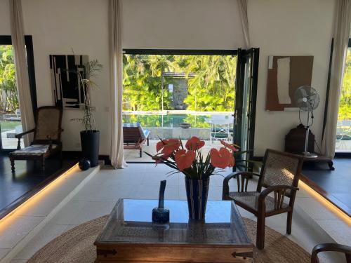 a living room with a vase of flowers on a table at Blue Palm Villa with Private Pool & Tropical Garden in Cap Malheureux