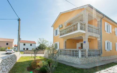 Casa amarilla grande con balcón en Apartments Ljubica, en Polje