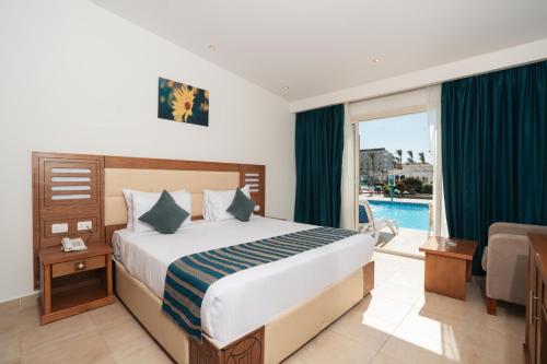 a bedroom with a bed and a balcony with a pool at Le Jardin Aqua Park Resort in Hurghada