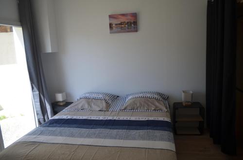 une chambre avec un lit et une fenêtre dans l'établissement Le Gravelot Royannais, à Royan