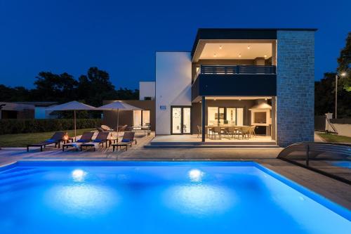 a villa with a swimming pool in front of a house at Villa dell Re in Žminj