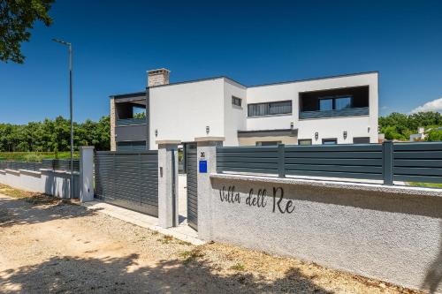 a white house with a fence and a wall with writing on it at Villa dell Re in Žminj