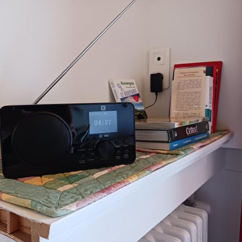 a shelf with a radio and books on it at Gîte les Bois in Orcival
