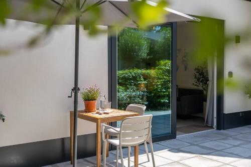 オーストカペッレにあるNEW Hello Zeeland - Magnolialaan 2のパティオ(テーブル、椅子、パラソル付)