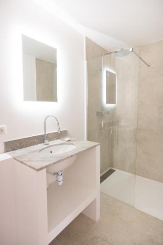 une salle de bain blanche avec un lavabo et une douche dans l'établissement Havre de Paix en Provence, à Aix-en-Provence